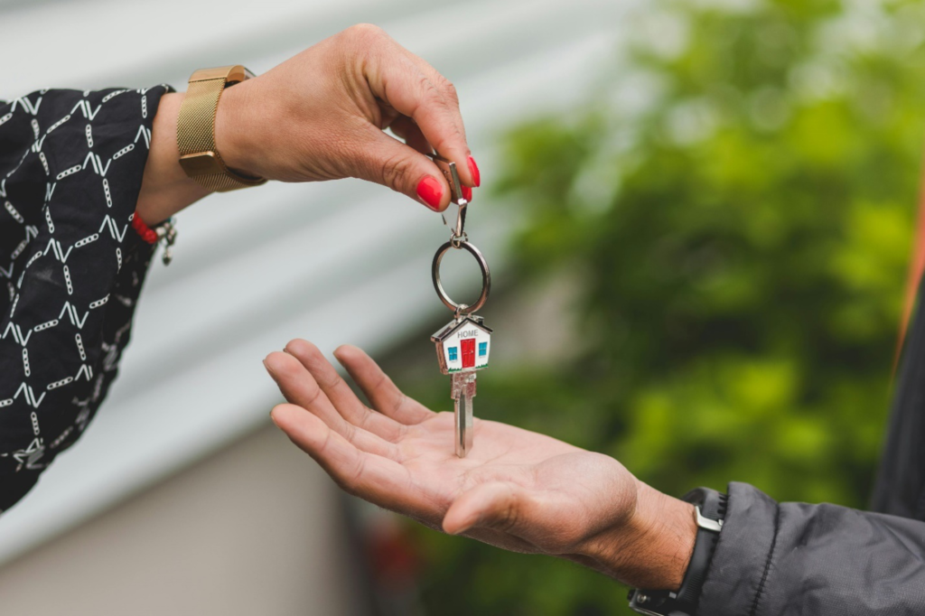 A picture of a person handing over keys to another one