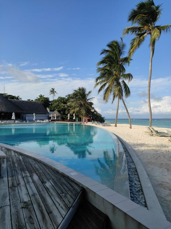 private pool with wooden pavement connected directly to a private beach