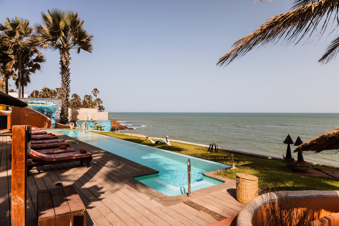 backyard of a luxurious house with a beach connected and a private pool