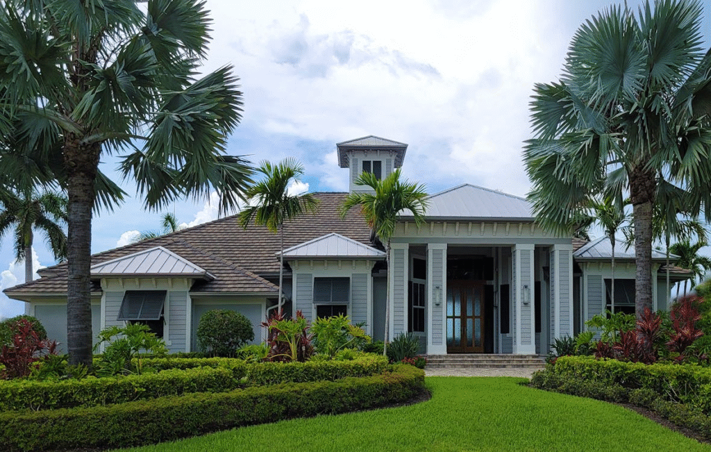 luxury house with palm trees around it, with a cloudy sky