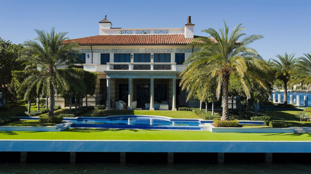 backyard of a luxury mansion with palm trees and a private pool